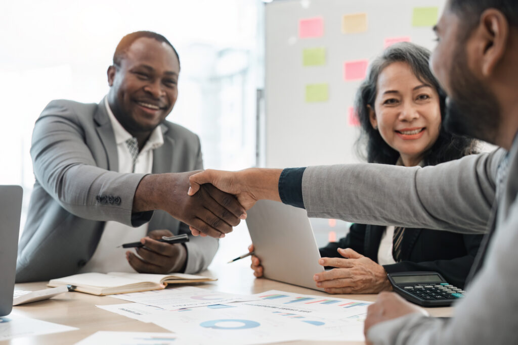Professionals shaking hands after a productive meeting, reflecting successful customer acquisition strategies.