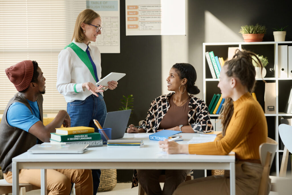 A mentor guiding a small group discussion while reviewing a professional development plan for career growth.